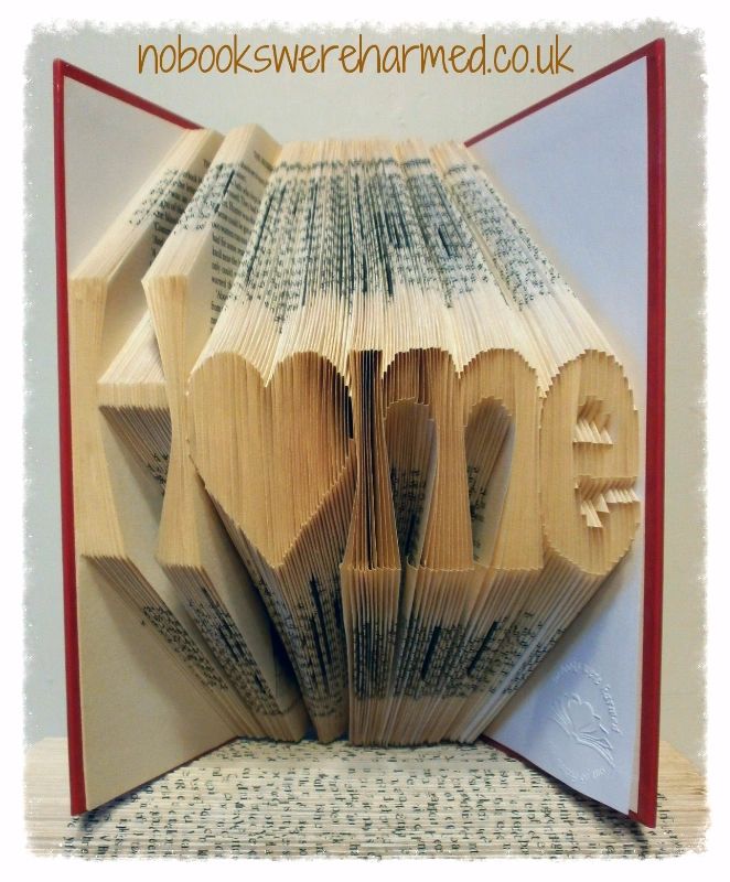 Handcrafted 'H♥me' art piece made from vintage book pages, featuring a heart-shaped 'o' for a unique home decor touch.